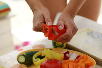 Woman slicing red bell pepper with knife