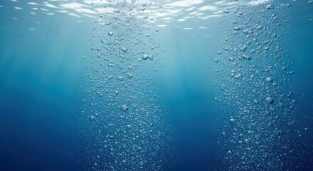 Underwater view of rising air bubbles in clear blue ocean water with sunlight filtering from above