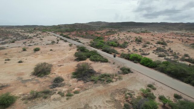 Desert road with lone motorcycle ride in vast, open landscape