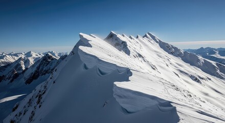 Aerial view of snow covered mountain range under a clear blue sky day