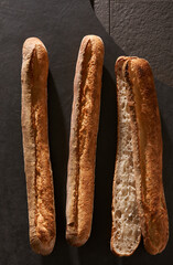 Golden Brown French Baguette on Dark Stone Background어두운 돌 배경 위 황금빛 갈색 프랑스 바게트