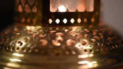 Close up of ornate metal lantern with illuminated details and warm lighting
