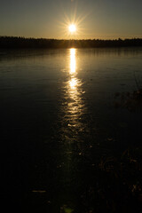 Moon on night sky over winter lake at night time. A moonlit path on the lake's ice in winter.
