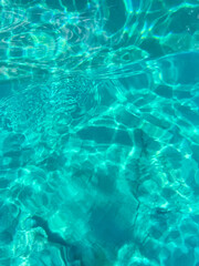 Turquoise sea ripples background texture, clear Mediterranean water with abstract patterns in bright sunshine, above view