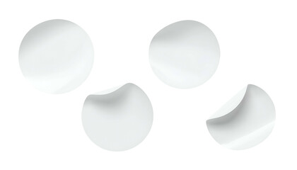 Four white circular objects with two partially peeled edges on a black background