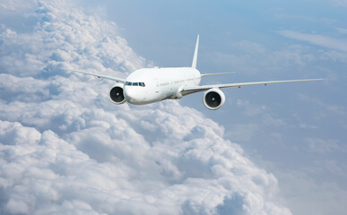 White passenger airplane flying in the sky amazing clouds in the background - Travel by air transport