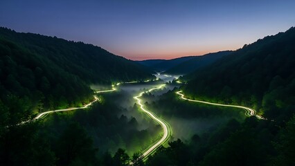 Captivating long exposure winding road through misty forest valley, glowing light trails.