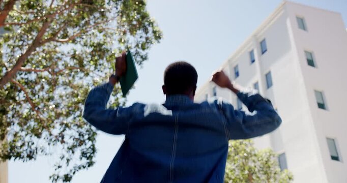 Jumping, celebration and man with tablet in city for good news, lottery winning or finance bonus. Happy, digital technology and back of male person with fist pump and energy for achievement in town.
