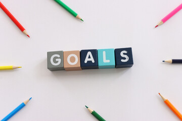 Fototapeta premium Wooden cubes with text goals on white textured background