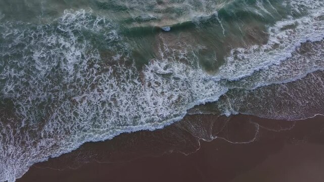 Ocean movement near beach. Waves forming white foam. Sea waves in constant motion. Powerful waves rising. Water waves approaching shore.