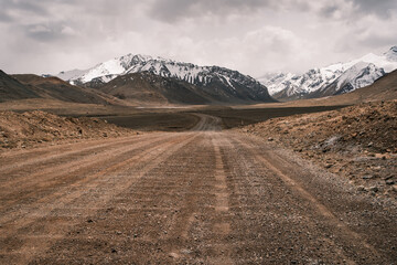 The legendary Pamir Highway (M41) stretching across the arid high-altitude landscapes of...