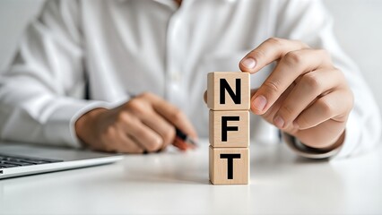 Business professional in white shirt holds wooden blocks with NFT letters, symbolizing digital assets and cryptocurrency investments in a modern office environment