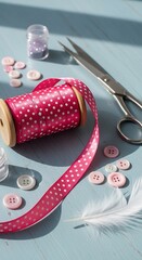 A vibrant collection of crafting supplies, including a spool of pink polka-dot ribbon, buttons, and scissors, displayed on a light blue wooden surface.