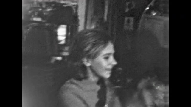 Funny man jokes with woman in house. Hilarious young couple. Happy female happily fools around with boyfriend in cozy room. Indoor time together. Old film. Archival retro 1960s. Vintage archive.