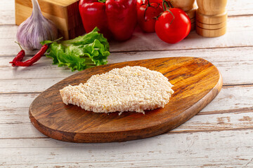 Raw breaded schnitzel for roast