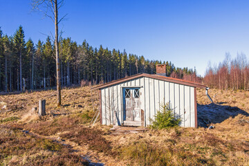 Wooden cabin on a clearing cut area in a woodland © Lars Johansson