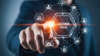 A finger touches a glowing hexagon displaying customer focus surrounded by icons representing business services and data analytics