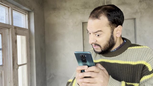 Frustrated angry man replying to scam message with angry and frustration. Annoyed man gets angry with scam messages and mails replying them with harsh words. Stressed man feels very angry writing SMS.