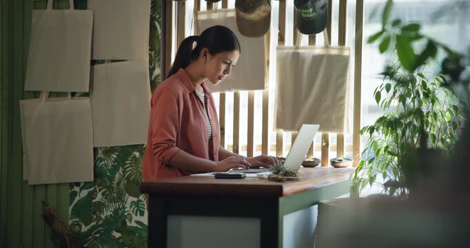 Woman, botanist and typing with laptop at shop, inventory management and contact supplier for stock. Person, computer and report with notes, review or check notification for deal at flower store