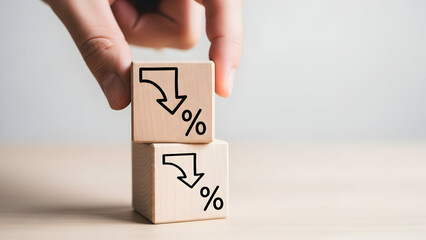 Two wooden blocks stacked with downward trending percentage symbols indicating financial decline
