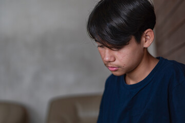 Obraz premium A quiet moment of reflection as a young boy sittings by the wall in his house, lost in thought, capturing the tenderness of growing emotions and unspoken stories.