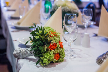 Elegant table setting with bouquet of roses at formal event