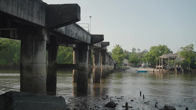 Serene riverside view in Ranong under a blue sky with rustic elements