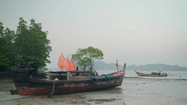 Serene Ranong scene with fishing boats at dawn on a misty shore