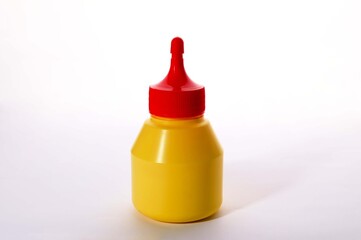Yellow glue bottle with red cap on white background for product and stock photography