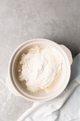 overhead view of focaccia dough being mixed in a claypot, top view of a high hydration focaccia bread dough in a donabe, process of making high hydration focaccia