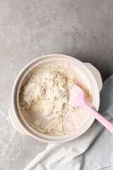 overhead view of focaccia dough being mixed in a claypot, top view of a high hydration focaccia bread dough in a donabe, process of making high hydration focaccia