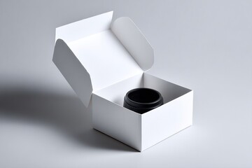 Black container inside a white box with the lid open, on a light gray surface with soft shadows.