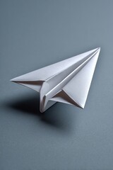 Paper airplane on blue background. Simple origami, childhood memories, handmade, flight, and imagination.