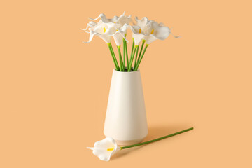 Vase with artificial lily flowers on beige background