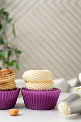 Close-up of a vanilla cupcake in a pink wrapper with buttercream frosting, cupcake in a pink liner with a cinnamon frosting