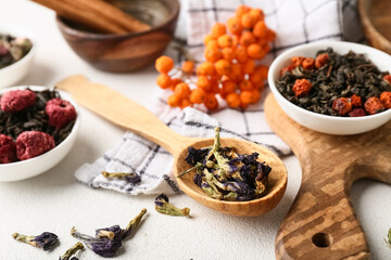 Spoon with dry fruit tea on white grunge table, closeup