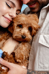 Loving couple embracing a fluffy puppy, showing pet care and family bonding