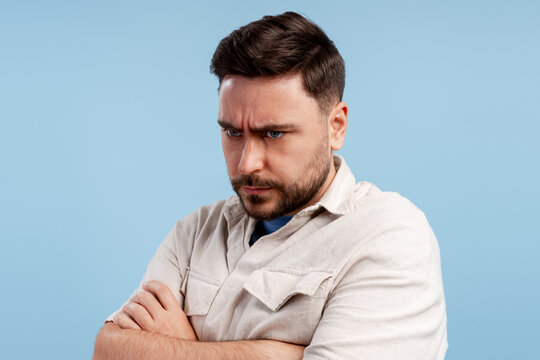 Man with a beard wearing a shirt, expressing anger, frustration, and dissatisfaction