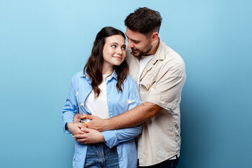 Fototapeta premium Young couple hugging and looking at each other celebrating Valentine's Day