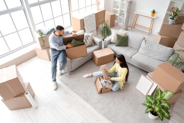 Happy young couple unpacking boxes in rented apartment on moving day, top view