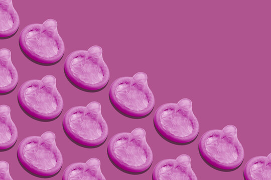 Group of a pink condoms on pimk background