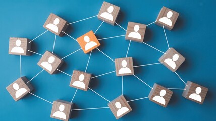 Network of wooden blocks with human icons connected by lines, one block highlighted in orange, symbolizing social network or team structure