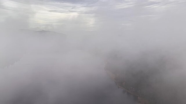 thick fog engulfing river canyon cliffs, search helicopter conducting training while ranger monitors erosion