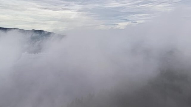 dense fog rolling over mountain ridges, drone surveyor mapping timbered slopes while hiker silhouette fades