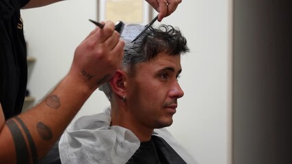 Customer chats with barber while getting first bleaching powder and oxidant treatment applied