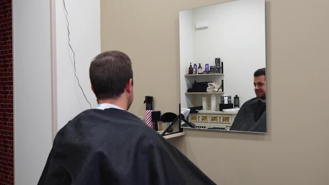 Barber prepares client by placing a white band and adjusting gown before haircut begins