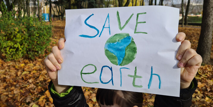 Young Girl Holds Save Earth Sign in Autumn Park - Powered by Adobe