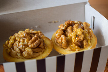 two tart pastries with walnut topping in box