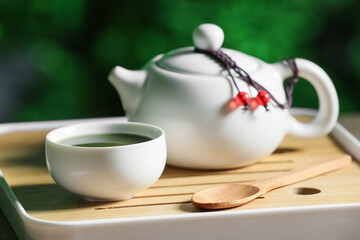 Tray with teapot, cup of tea and spoon for ceremony on table outdoors, closeup
