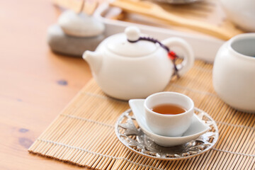 Asian tea set on wooden table in room, closeup
